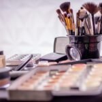Close-up of a professional makeup brush set and cosmetics on a table for beauty use.