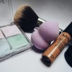 A flat lay showcasing various makeup essentials including brushes, sponges, and cosmetics.