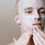 Close-up of a man applying facial cleanser for a refreshing skincare routine, focusing on self-care and health.
